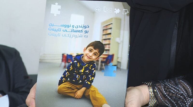 Dayîkekê ji bo zarokê xwe yê bi otîstîk pirtûk...